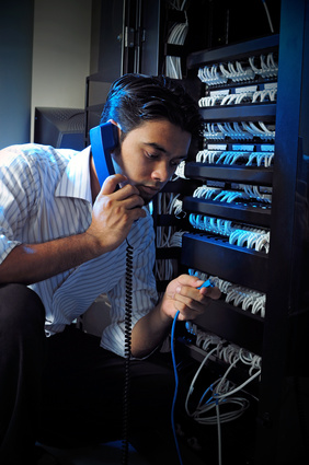 IT Guy listens to phone and plugs in a cable