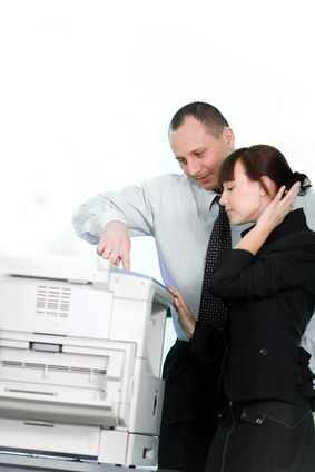 Engineer shows a client how to use a photocopier feature